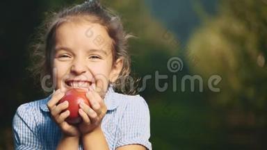 小<strong>女孩正</strong>拿着一个红苹果靠近她的<strong>脸</strong>。 <strong>女孩</strong>笑容满面。 快关门。 复制空间。 4K.